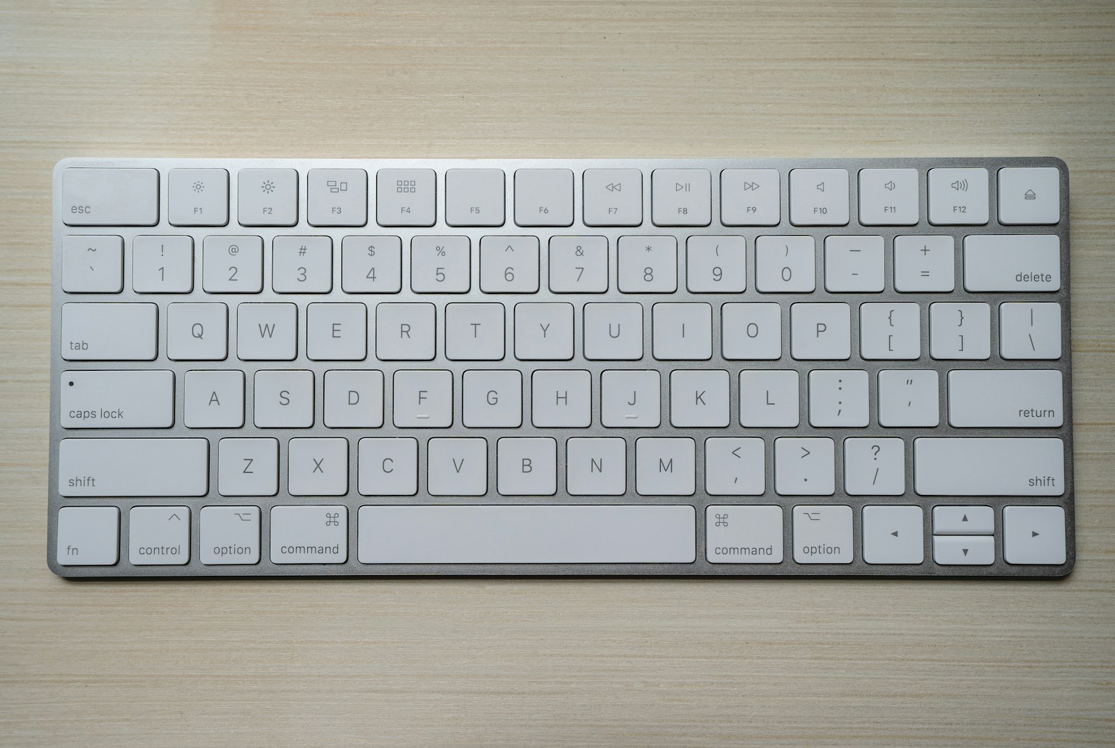 Anodized aluminum mechanical keyboard with brass weight and PBT keycaps on walnut desk